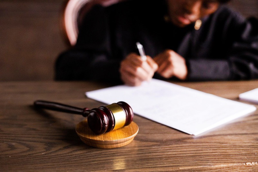 Gavel next to judge doing paperwork