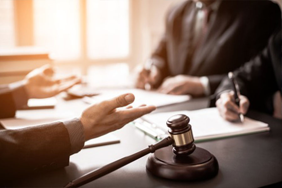 Gavel on table and businessmen talking with lawyers