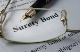 Surety Bond information on paper with glasses and pen