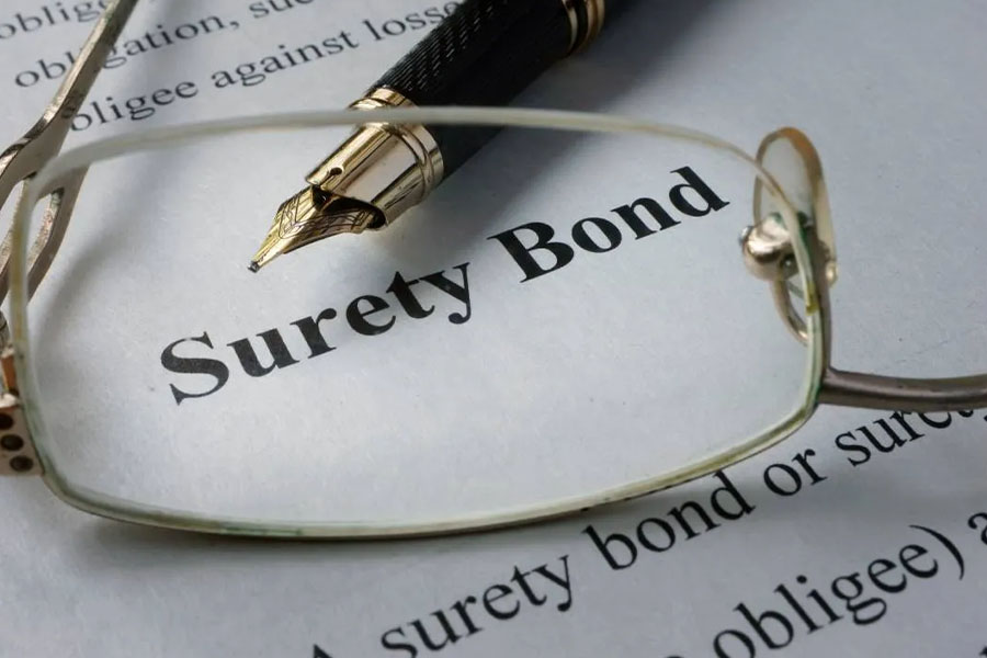 Surety Bond information on paper with glasses and pen